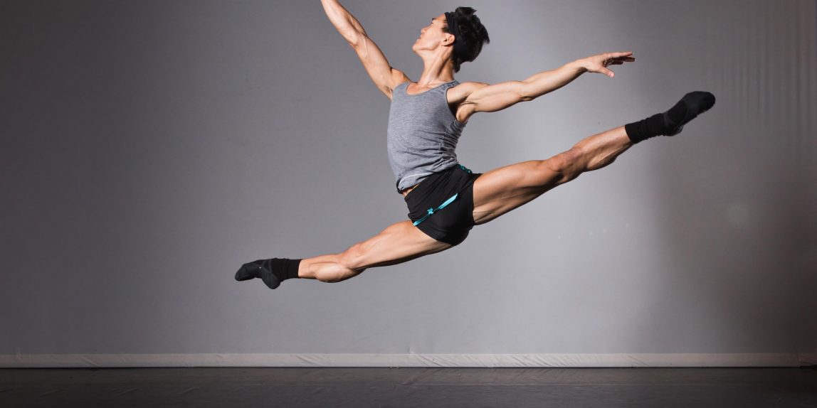 Ballet Dancer Jim Nowakowski in midair, legs and arms spread wide.