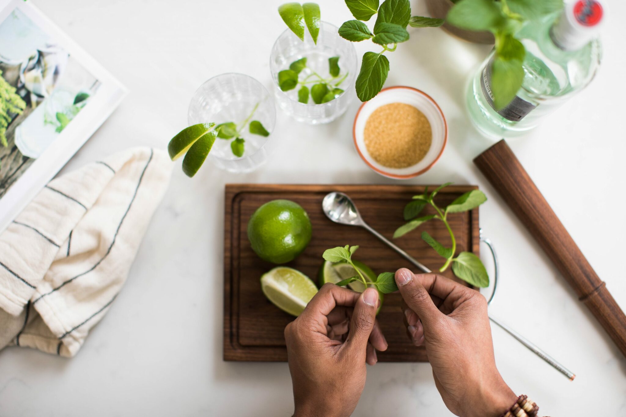 Two hands cooking with lime on a cutting board.