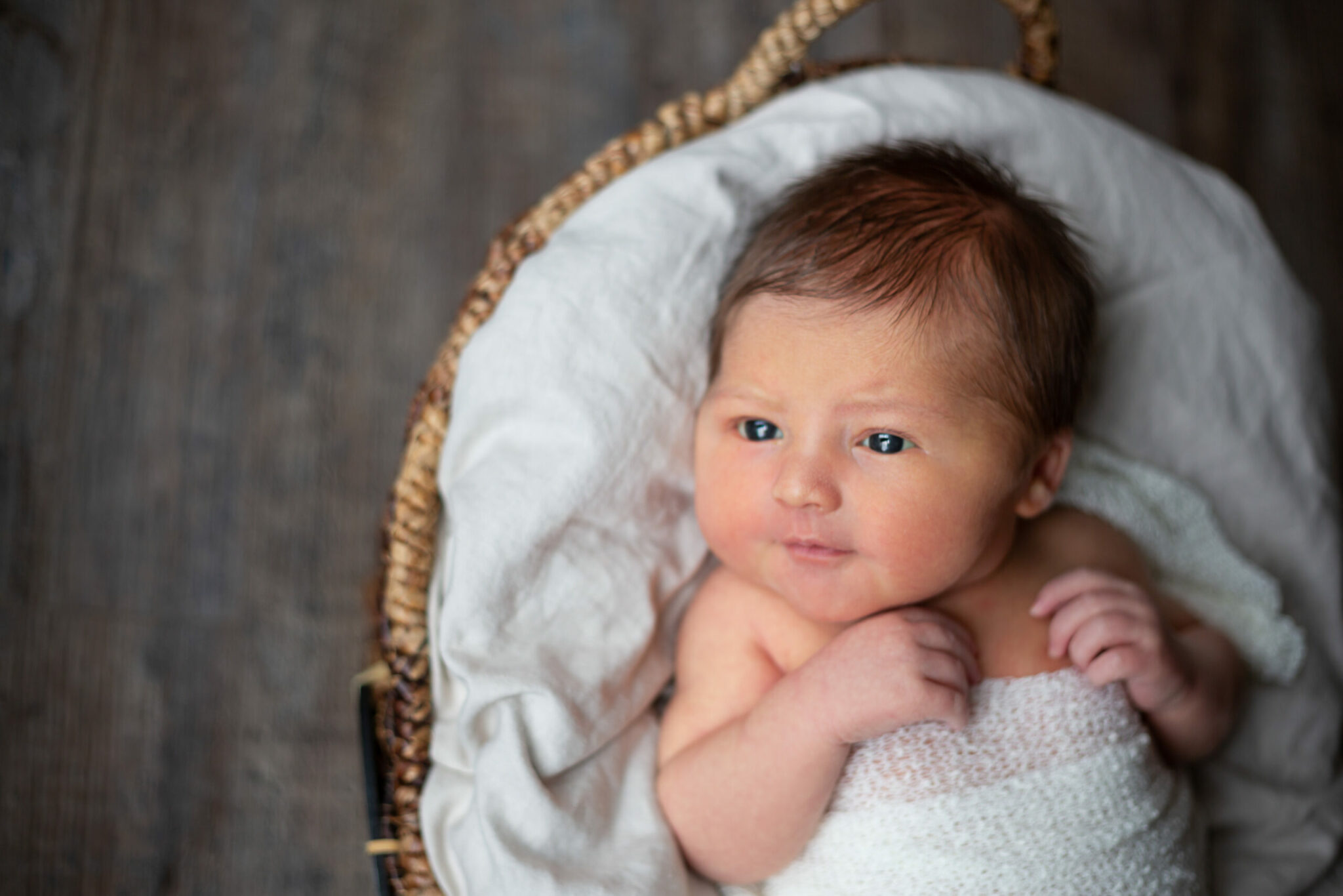 A little baby swaddled in a white blanket