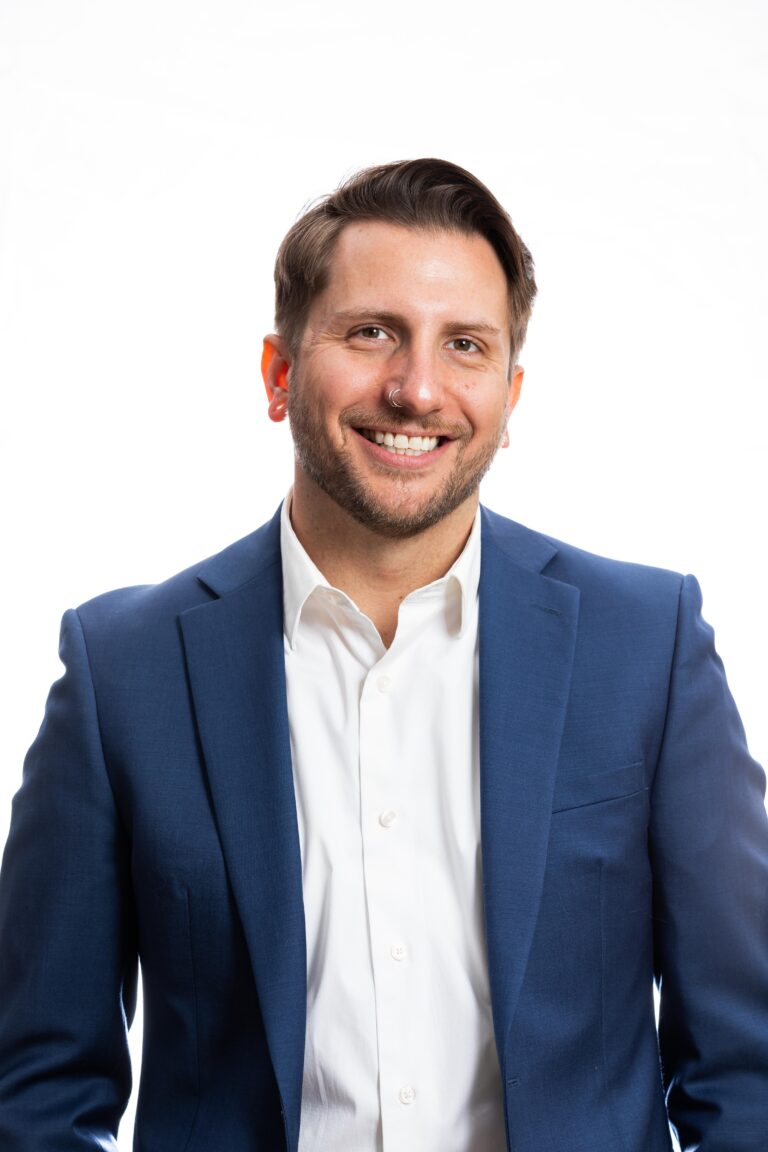 F85A8791 A professional realtor headshot of a smiling man with dark hair